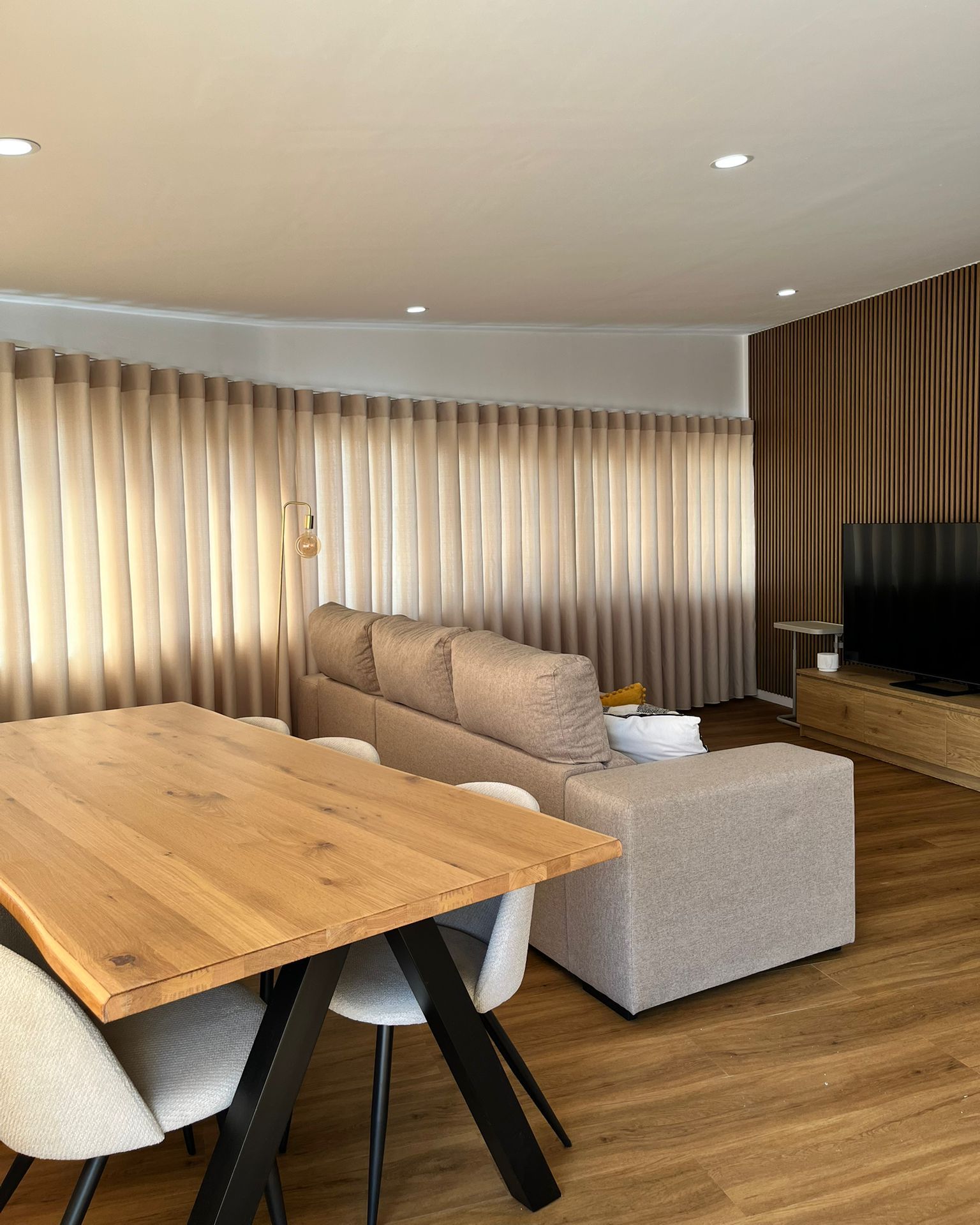 Fotografia real de sala com cortinados, mesa e sofá publicada pela APAVI